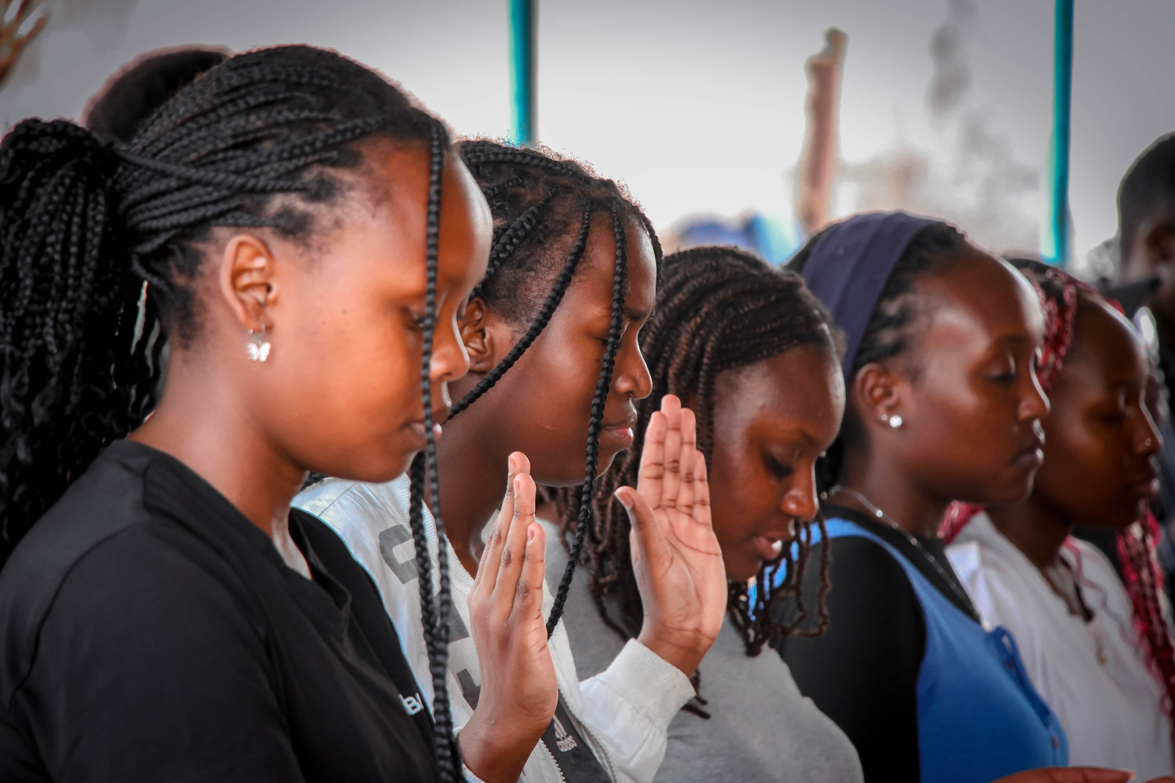 A quiet outdoor circle of young people gathered in reflection at dusk.